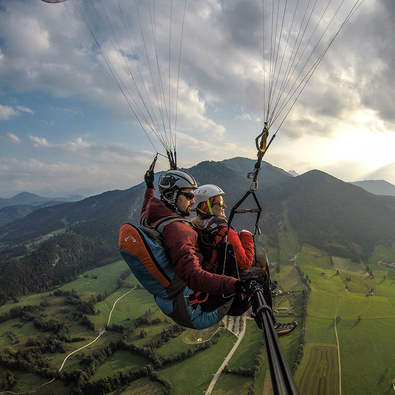 Tandem-Gleitschirmflieger vor den Gipfel des Brauneck